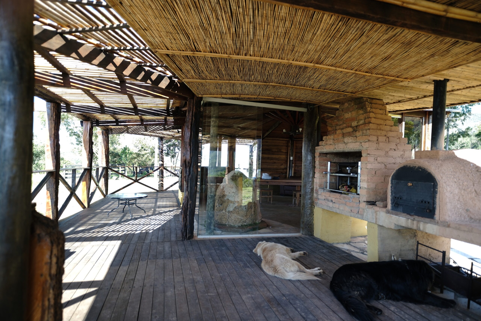 Varanda coberta com trançado de bambu e forno a lenha