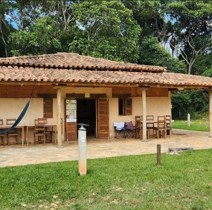 Varanda de convívio com rede e mesas artesanais